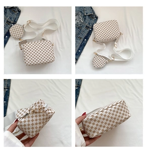 Detail view of a white printed crossbody bag with small round coin purse and wide strap