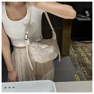 Detail shot of iridescent crescent crossbody bag with adjustable canvas shoulder strap