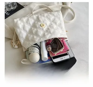 Vue de dessus du sac bandoulière blanc matelassé avec rangement pour téléphone et tablette