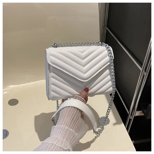 Detail of white quilted leather shoulder bag with V-shaped stitching and silver chain