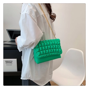 Detail of bright green quilted bubble shoulder bag with a chunky gold chain strap