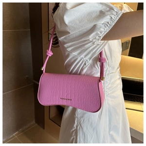 Detail of pink faux crocodile skin shoulder bag featuring gold embossed fashion logo