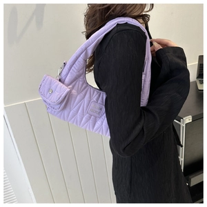 Détail d'un sac à bandoulière matelassé violet avec une petite pochette zippée assortie