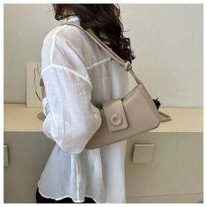 Chic beige leather baguette bag shown as a sleek underarm shoulder accessory style
