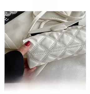 Vue détaillée de la texture en cuir blanc matelassé et de l'anse tressée du sac à main