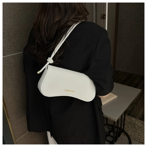 Close-up of a white crescent-shaped shoulder bag with gold lettering and knotted strap detail