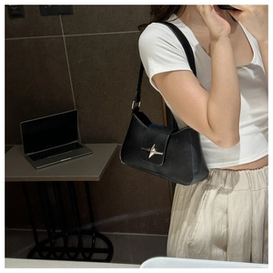Détail du sac sous le bras en cuir noir avec boucle étoile argentée en style décontracté