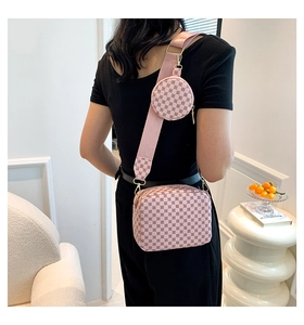 Detail of pink monogram crossbody bag with small round pouch and wide fabric strap
