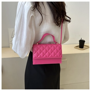 Detail der fuchsiafarbenen Stepptasche mit Rautenmuster und oberem Tragegriff