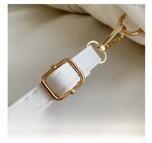 Vue détaillée de la bandoulière en cuir blanc avec boucle de réglage en métal doré