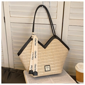 Detail of straw tote bag with wave texture, black leather trim and decorative scarf