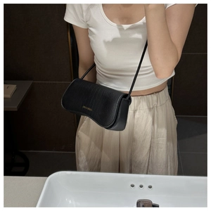 Mirror selfie showing a black crocodile pattern half-moon shoulder bag with gold logo