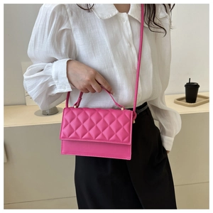 Detailansicht der gesteppten Rautenmuster auf der leuchtend rosa Damen Handtasche aus Leder