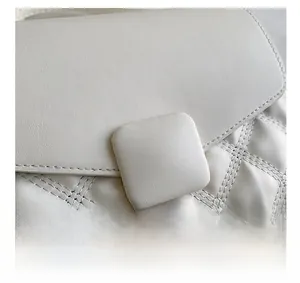 Détail du sac à rabat matelassé blanc montrant la texture du cuir et la boucle