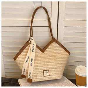 Detailed macro of beige straw tote bag with brown leather handles and silk scarf