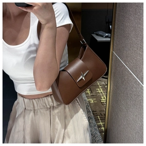 Détail d'un sac d'épaule en cuir marron foncé avec boucle étoile argentée