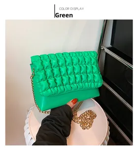 Close-up of green quilted shoulder bag featuring premium texture and gold chain strap