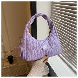 Détail du sac matelassé lavande avec surpiqûres ondulées et mini porte-monnaie assorti