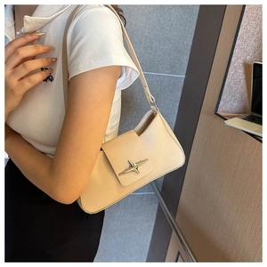 Gros plan du sac crème avec boucle étoile dorée élégante et détails en cuir texturé