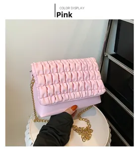 Detail of pink quilted shoulder bag featuring square pleats and gold chain strap