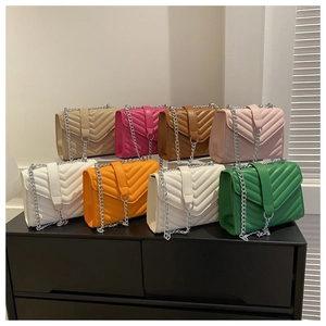 Detailed display of colorful quilted crossbody bags with chain straps in multiple vibrant hues