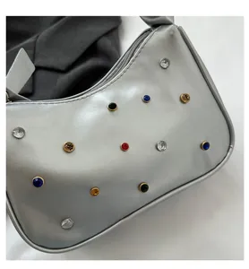 Nahaufnahme der silbernen Halbmandtasche mit bunten Strasssteinen und Metallic-Finish