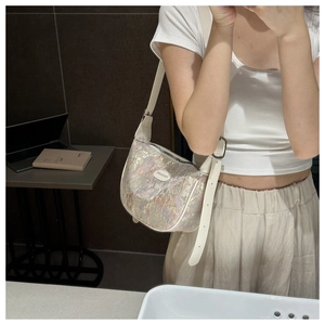 Detail of laser-effect iridescent dumpling bag with white adjustable leather strap