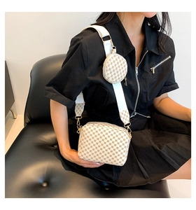 Detail of printed small square bag with round coin purse on white fabric shoulder strap