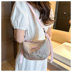 Detail of pink floral jacquard texture on crossbody bag with adjustable leather strap