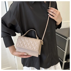 Detailaufnahme einer gesteppten Mini-Umhängetasche in Beige mit eleganten Metallbeschlägen