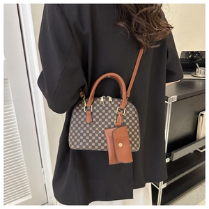 Detail of Boston bag with golden dot pattern, round leather handles and long shoulder strap