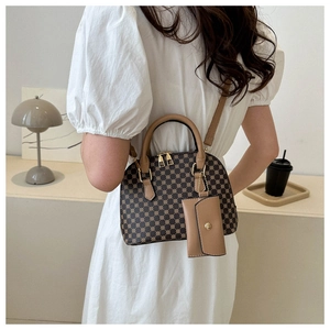 Detail of vintage checkered shell bag with small matching pouch and gold zipper accents