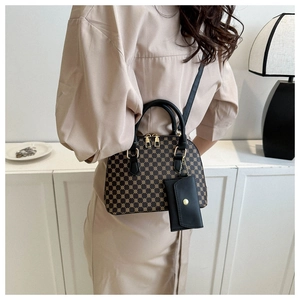 Detailed shot of vintage brown shell bag with geometric patterns and gold zipper hardware