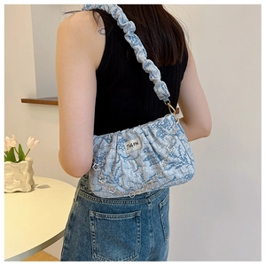 Détail du sac à bandoulière plissé bleu clair avec motif marbré et chaîne métallique