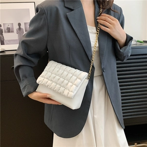Chic white bubble textured crossbody bag with gold chain strap worn by a female model