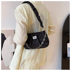 Détail du sac nuage plissé noir avec chaîne florale argentée et étiquette de marque