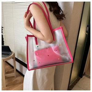 Detail view of pink transparent tote bag with colorful rhinestones and inner pouch bag