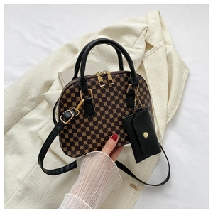 Detail of vintage shell bag with retro pattern, black handles and mini pouch on blazer