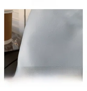 Close-up of high-quality light grey nylon fabric with a fine diagonal twill weave texture