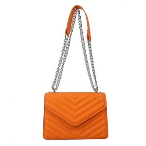 V-quilted orange crossbody bag with silver chain strap on a white background