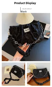 Détail du sac bandoulière plissé noir avec chaîne à pétales argentée et étiquette textile