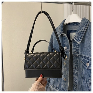 Makro-Detail der schwarzen gesteppten Handtasche mit edlen goldfarbenen Metallelementen