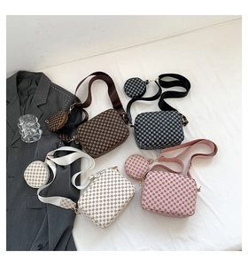 Detail view of printed crossbody bags in four colors with round coin purses and canvas straps