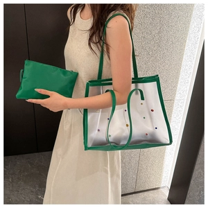 Detail of transparent tote with green leather trim and colorful rivets with inner pouch