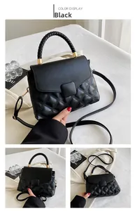 Détail du sac bandoulière matelassé noir avec poignée tressée et finitions dorées