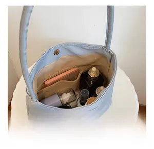 Internal view of blue nylon tote bag showing spacious lining and multiple storage pockets