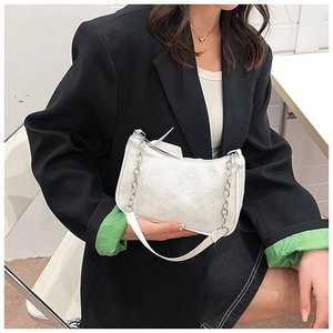 Close-up of white floral texture and silver chain strap on a stylish shoulder bag