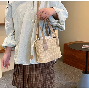 Detail of hand-woven straw bag with light brown leather strap and drawstring liner
