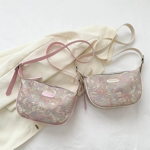 Floral jacquard crossbody dumpling bags in pink and purple with adjustable straps