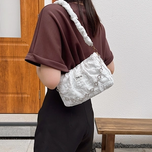Sac sous le bras plissé blanc élégant avec chaîne fleurie porté en bandoulière